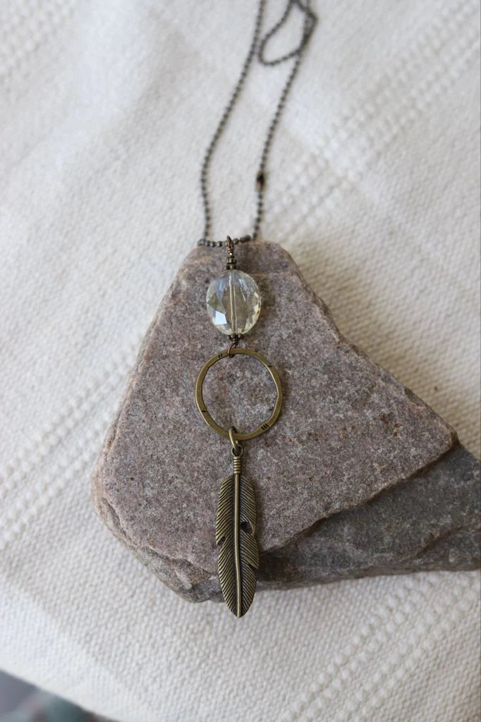 Antiqued gold necklace with feather charm and crystal